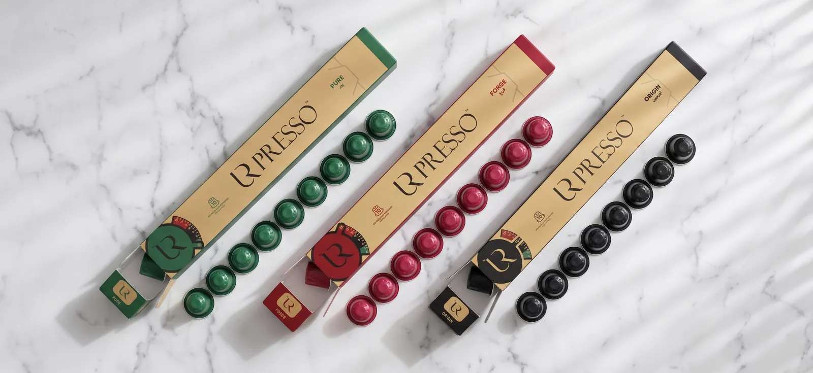 Les trois étuis URPRESSO ouverts sur du marbre, capsules alignées
